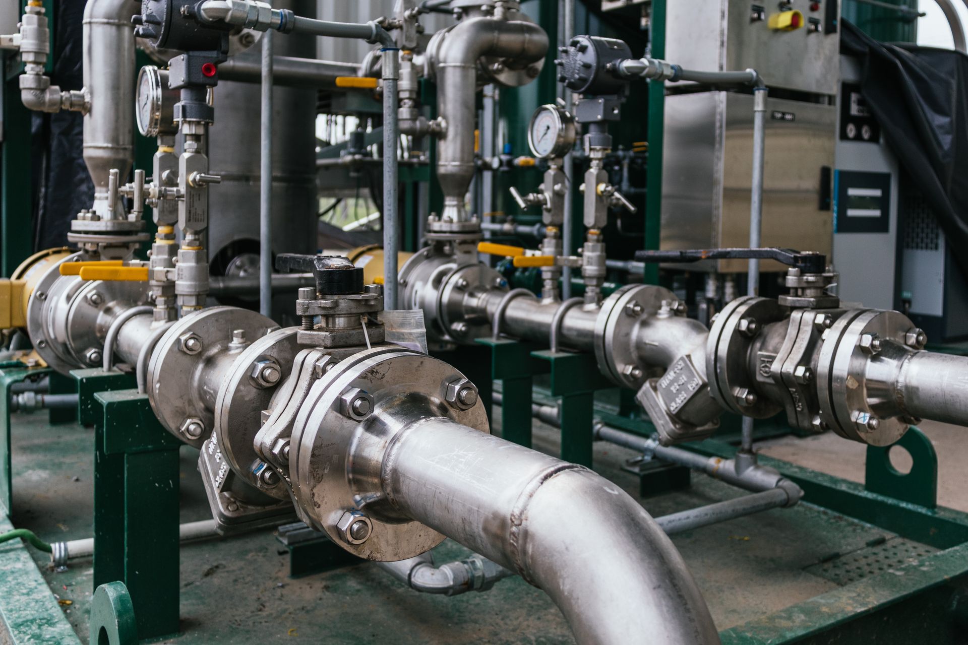 A row of stainless steel pipes and valves in a factory.