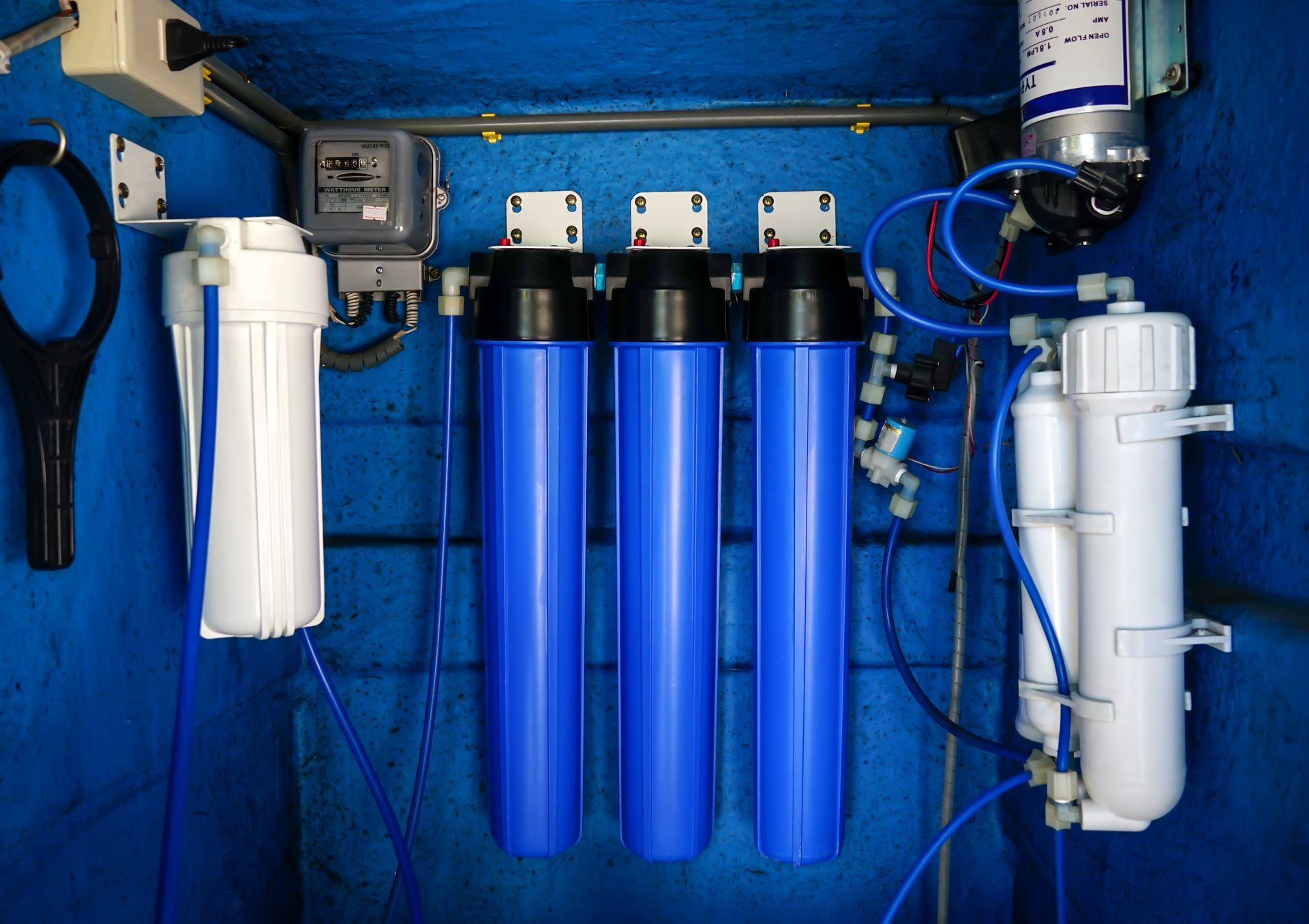 A row of blue and white water filters hanging on a blue wall