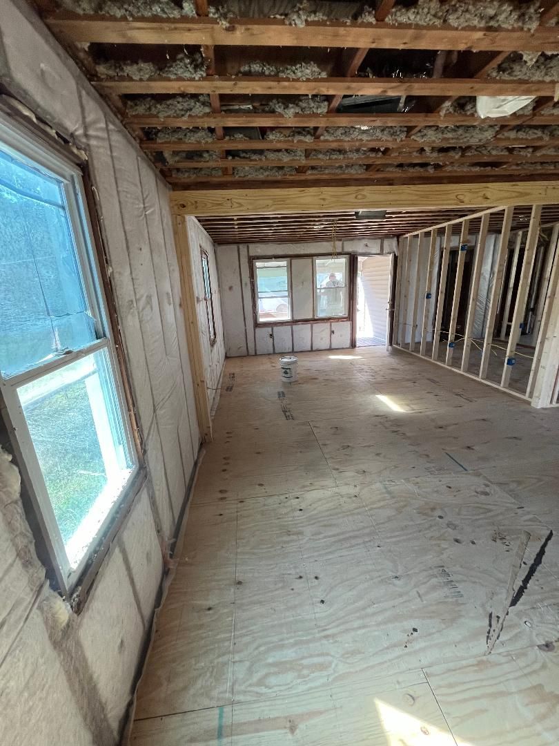 A large room with a lot of windows and a wooden floor.