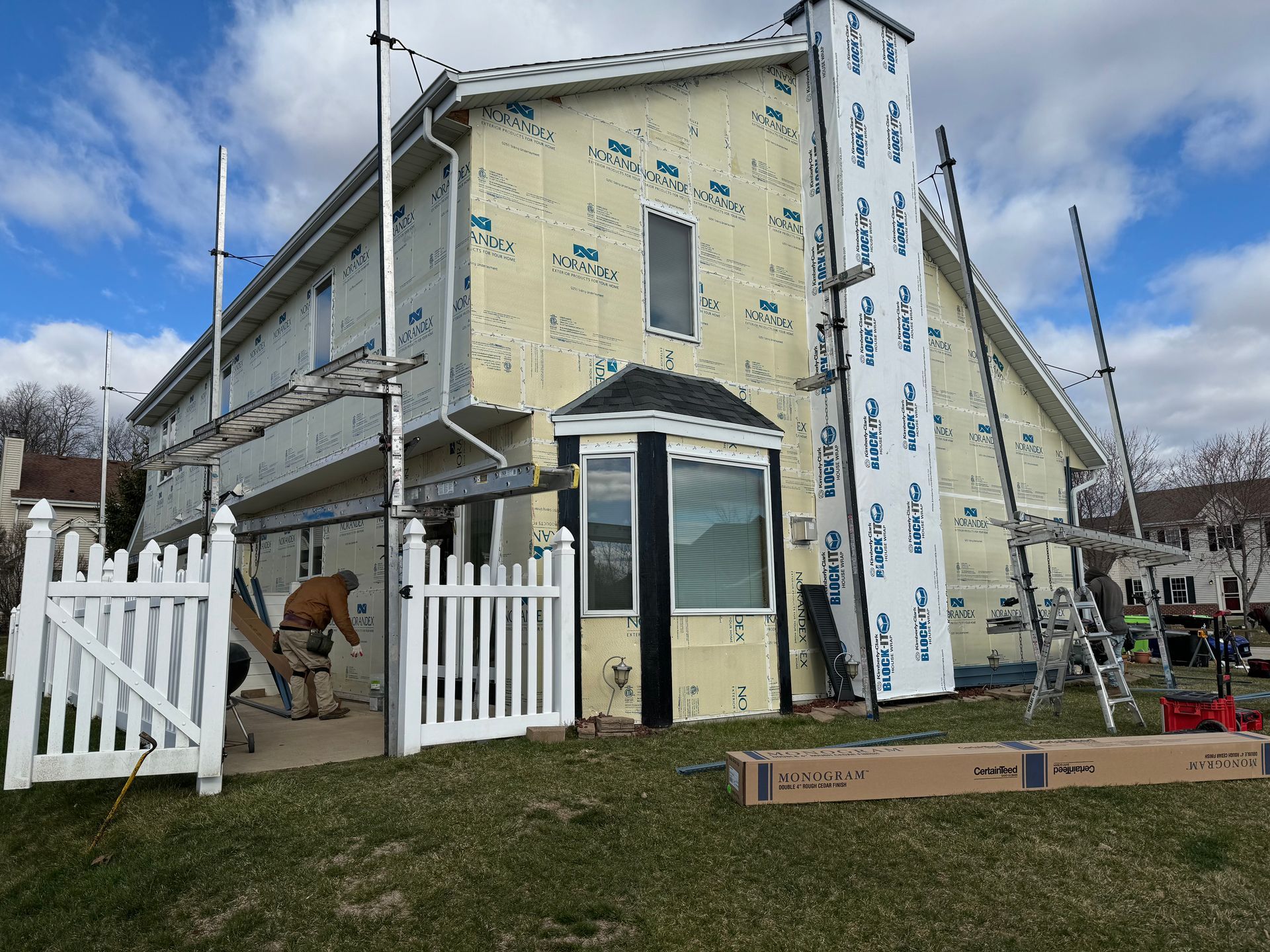 A house with a white picket fence is being remodeled