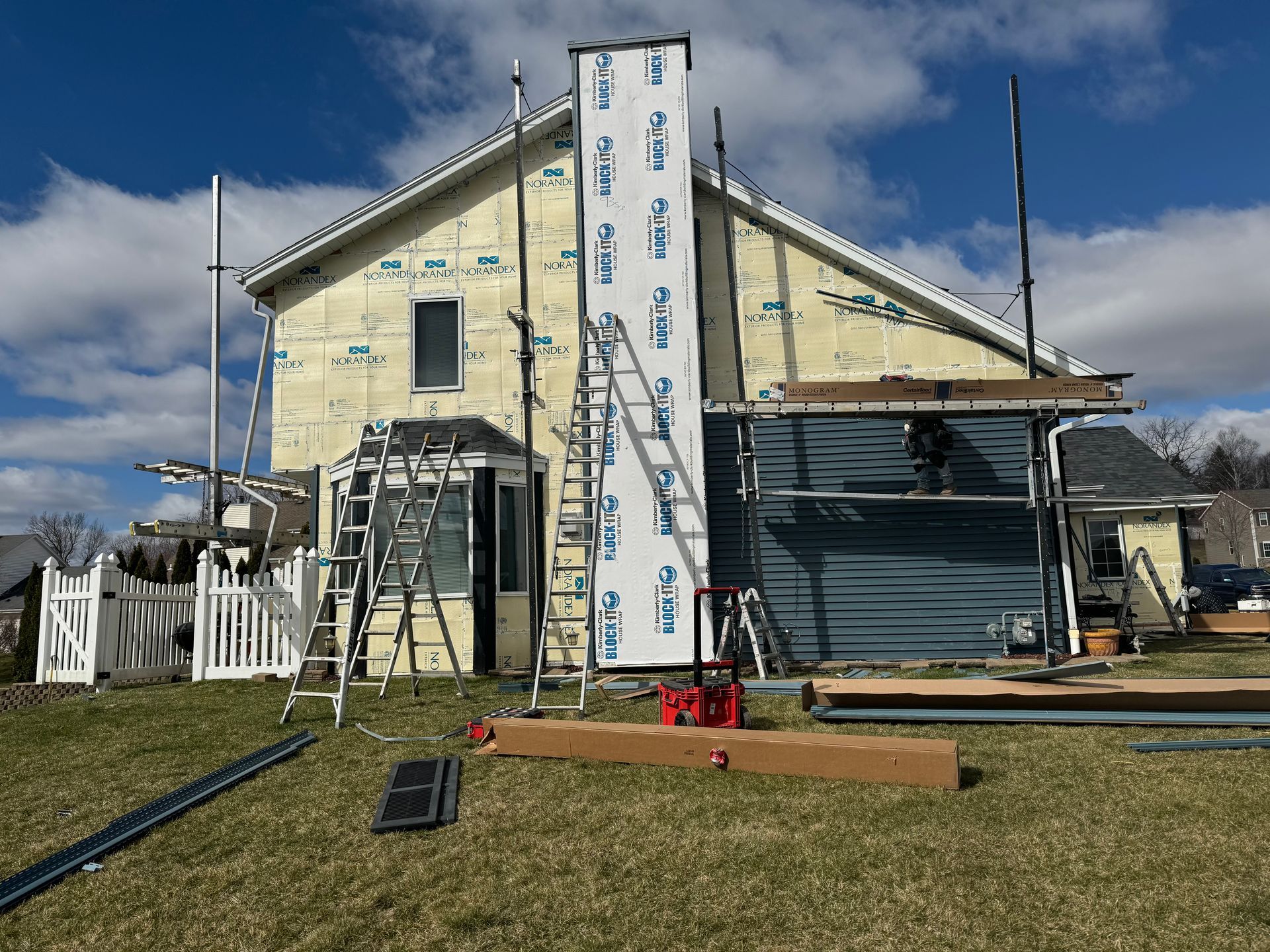 A house is being remodeled with scaffolding and a ladder.