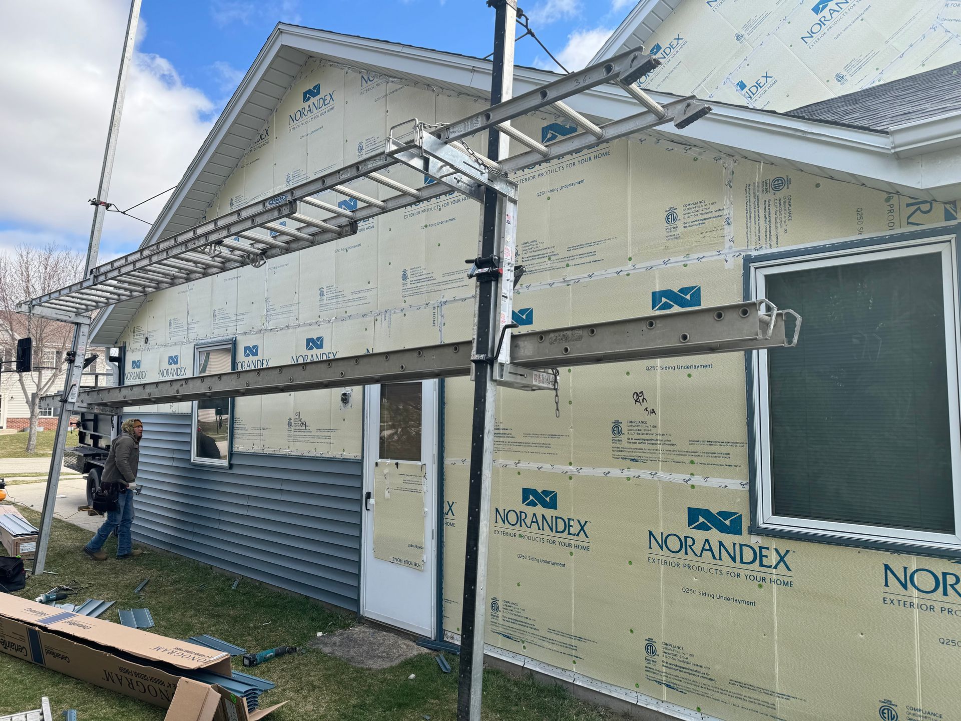 A man is standing in front of a house that is being remodeled.
