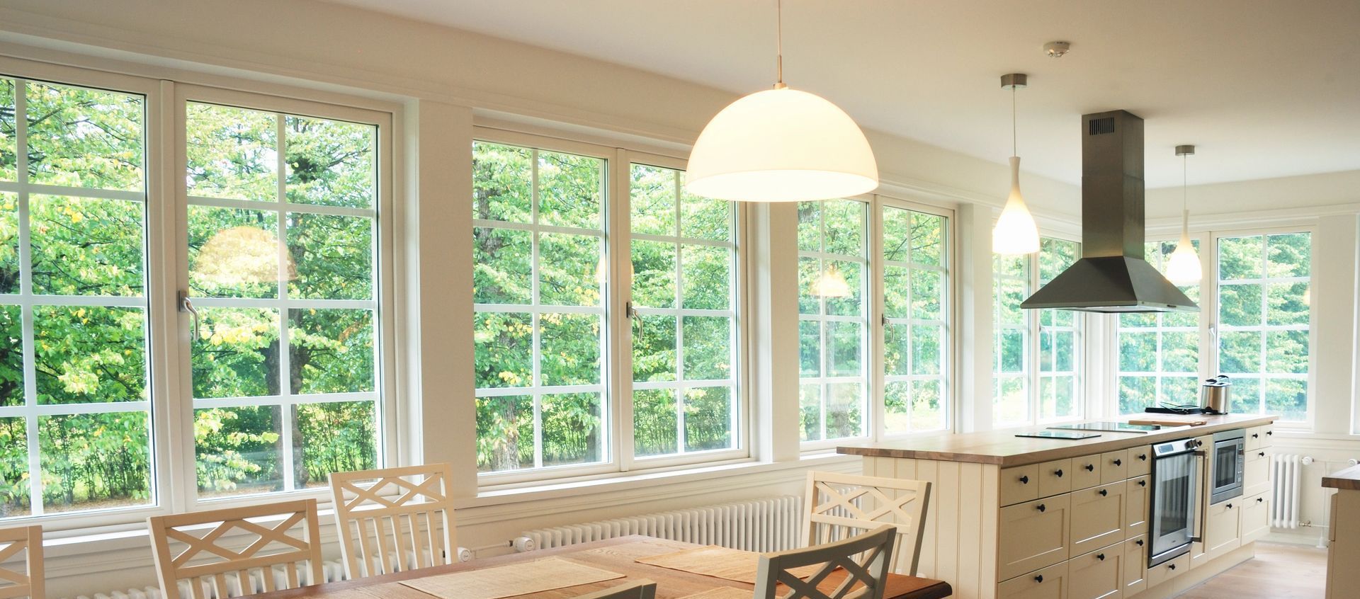 A kitchen with a lot of windows and a table and chairs