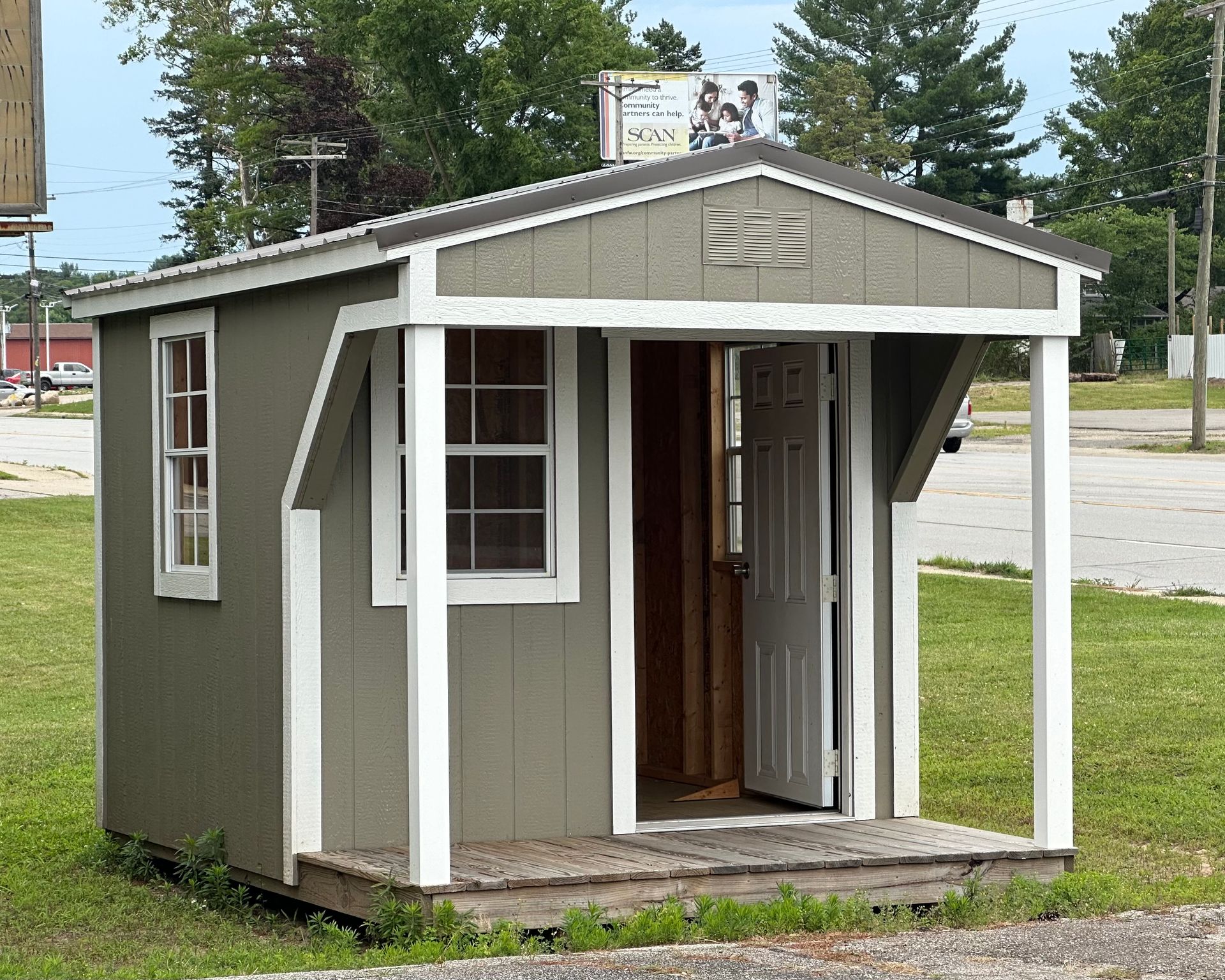 A small shed with a porch on the side of it