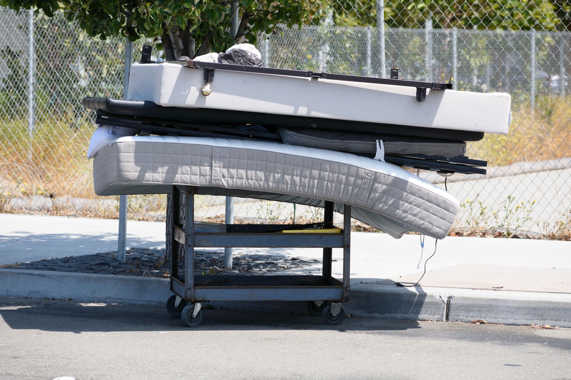 A bunch of mattresses are stacked on top of each other on a cart