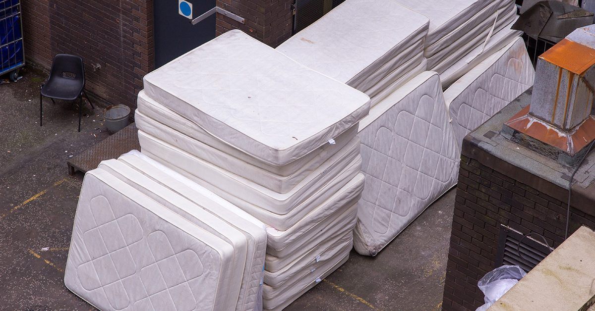 A stack of mattresses sitting on top of each other on the ground.