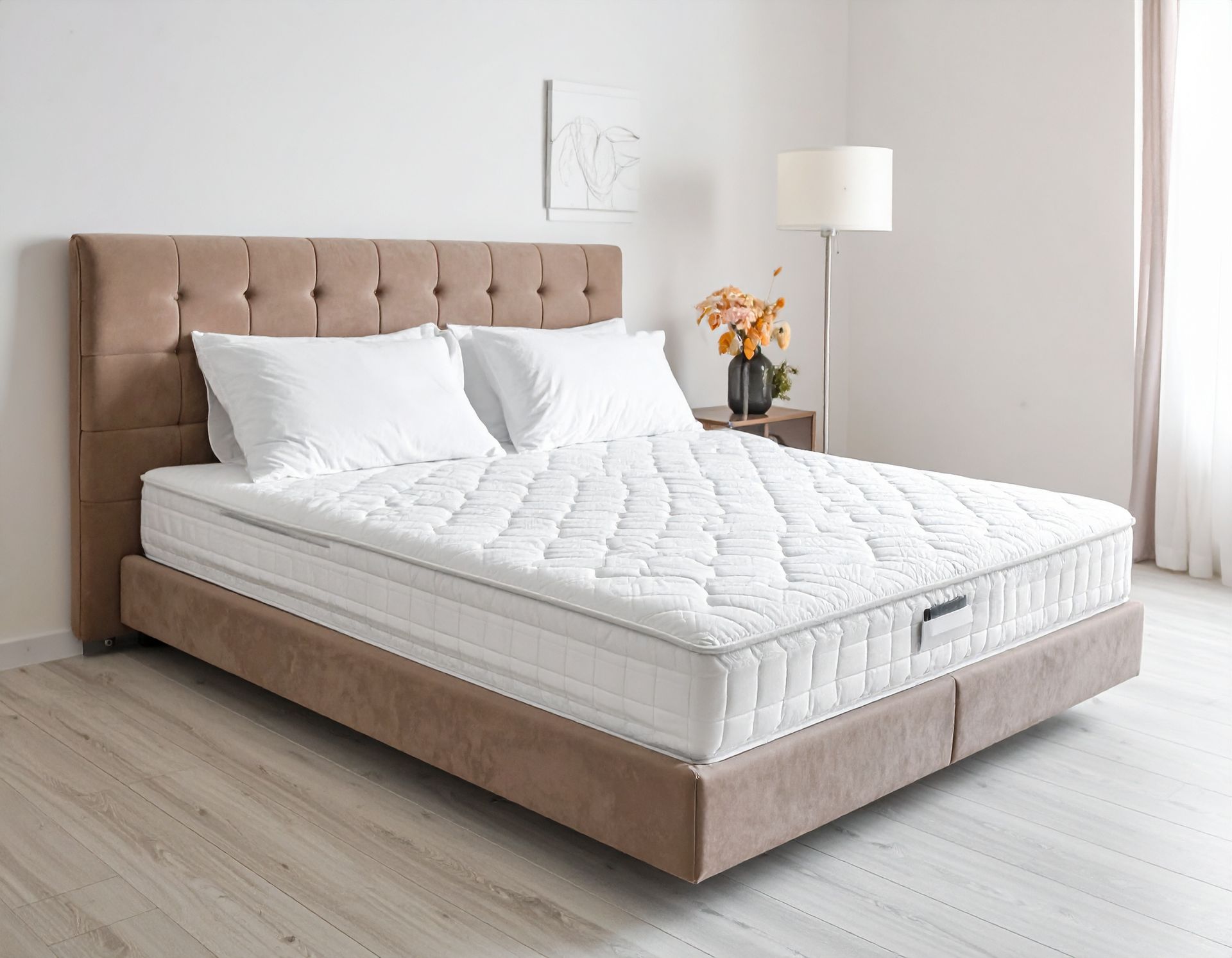 A beige bed with a tufted headboard, two pillows, and a white mattress in a bedroom setting.