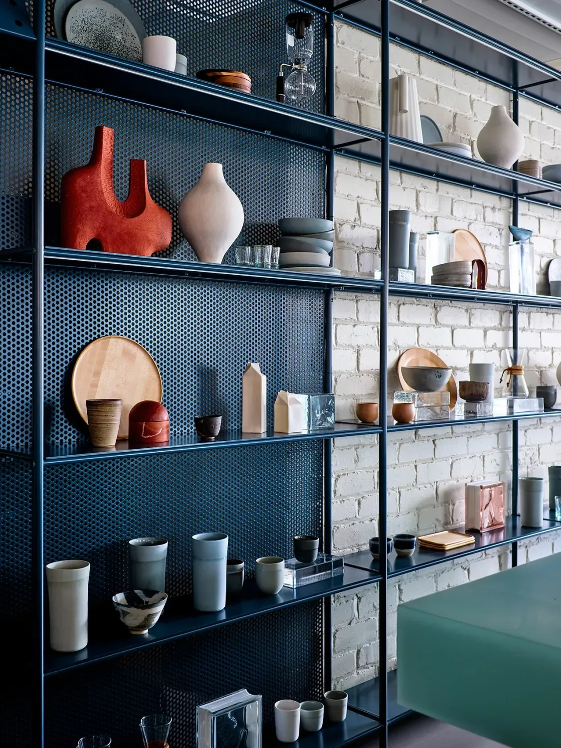 A room with a lot of shelves filled with vases and plates.