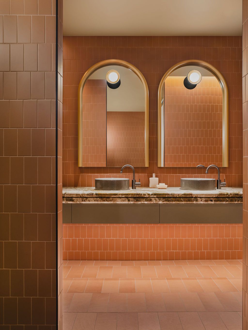 A hallway with wooden walls and sliding doors leading to a living room.