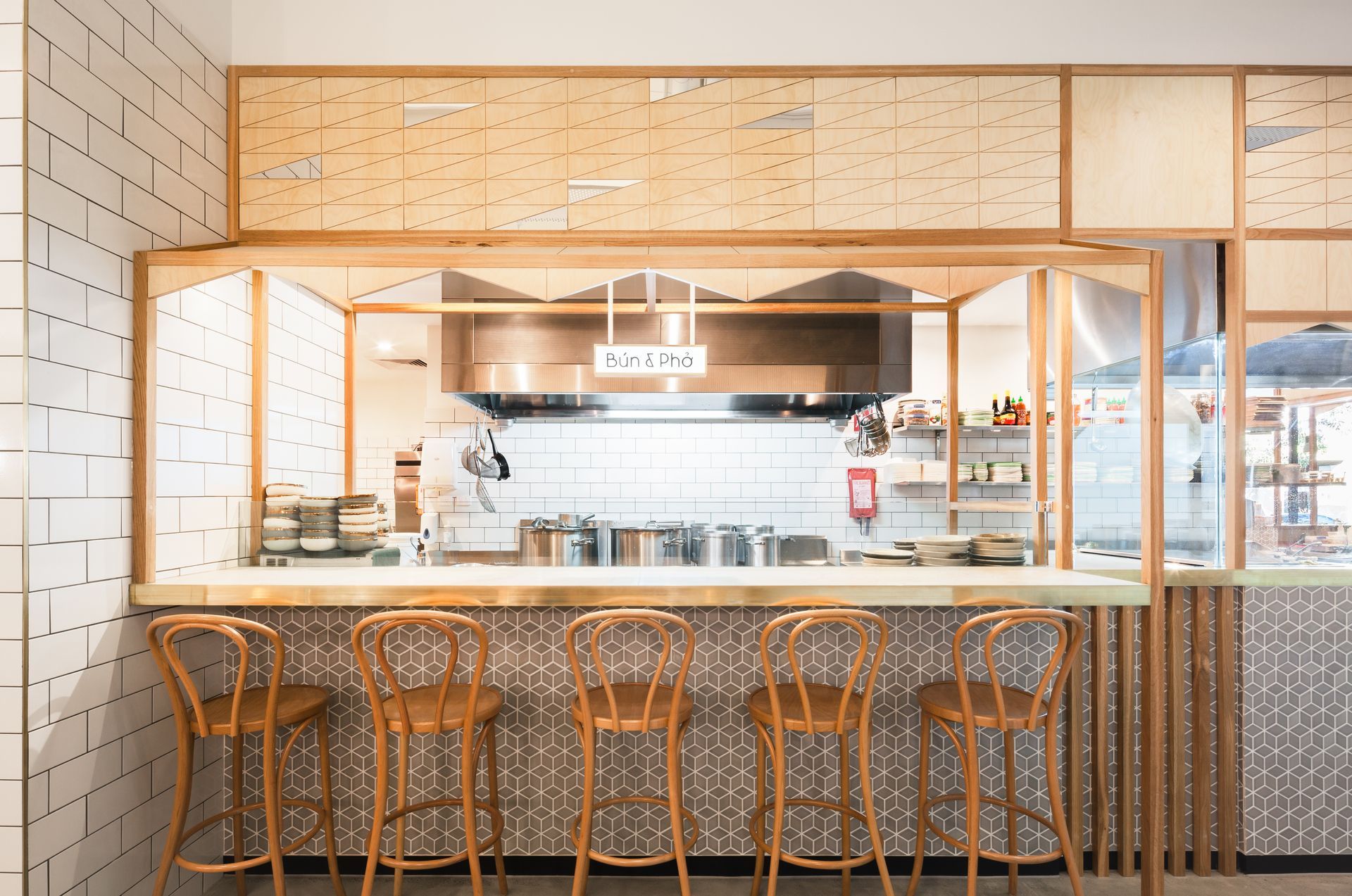 A kitchen with a long counter and stools in front of it.