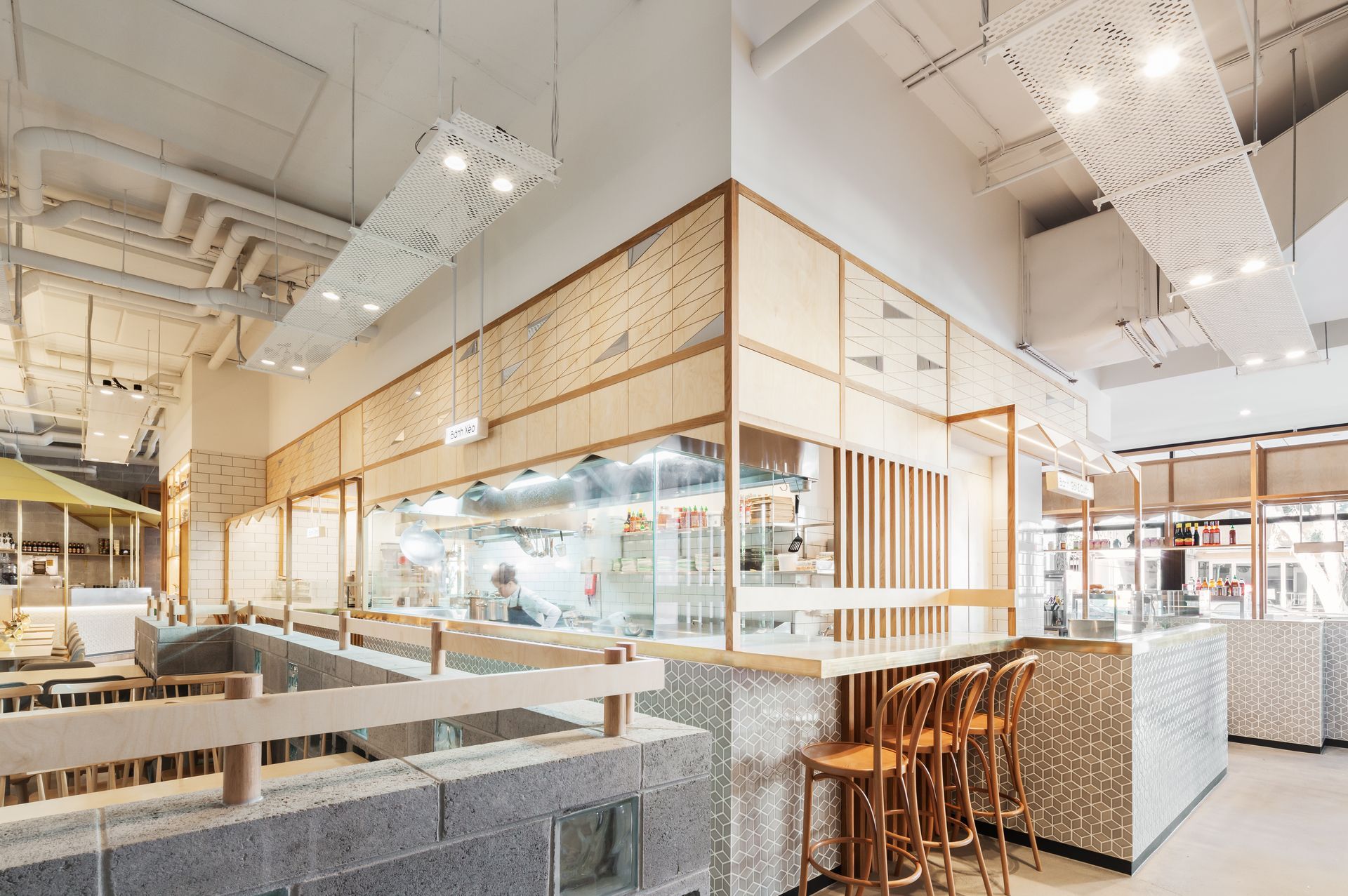 A restaurant with a lot of tables and chairs and a kitchen in the background.