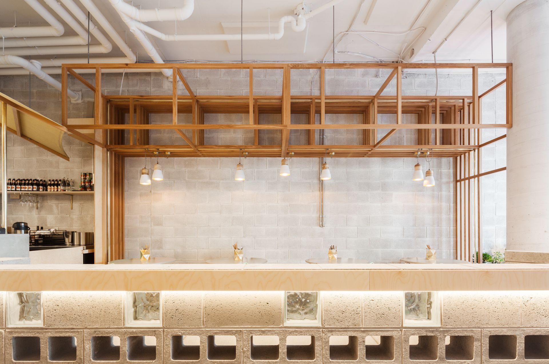 A restaurant with a wooden shelf hanging from the ceiling.