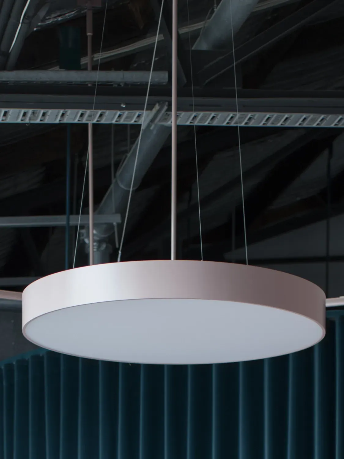 A round light hanging from the ceiling in a dark room