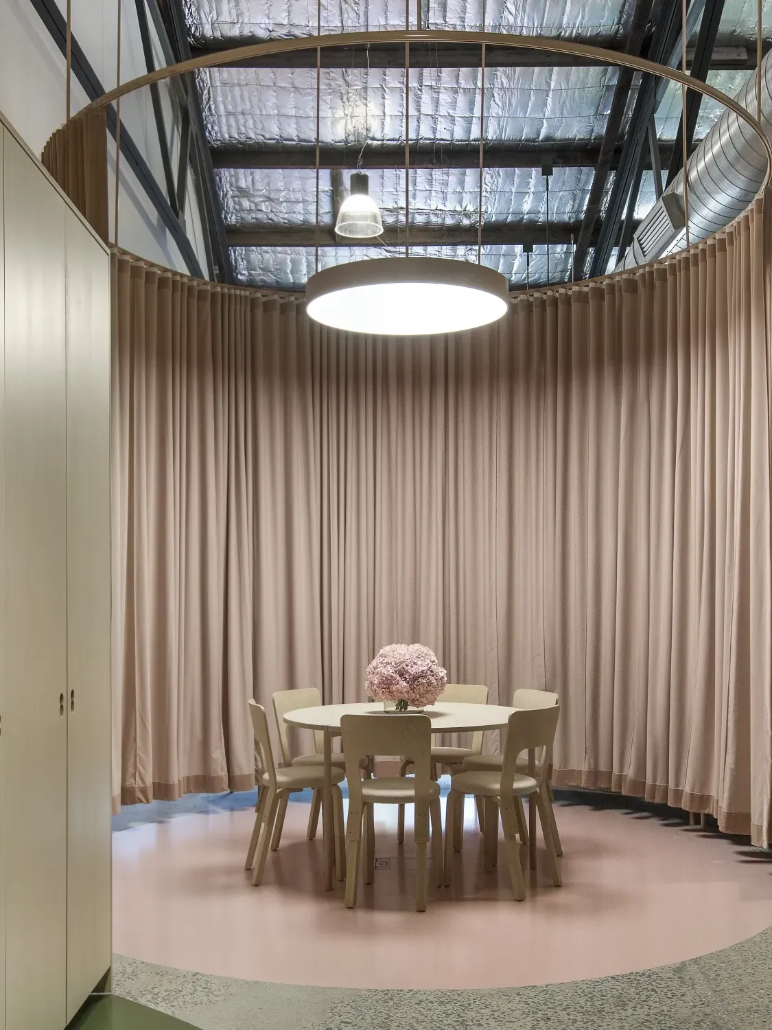 There is a round table and chairs in the middle of the room.