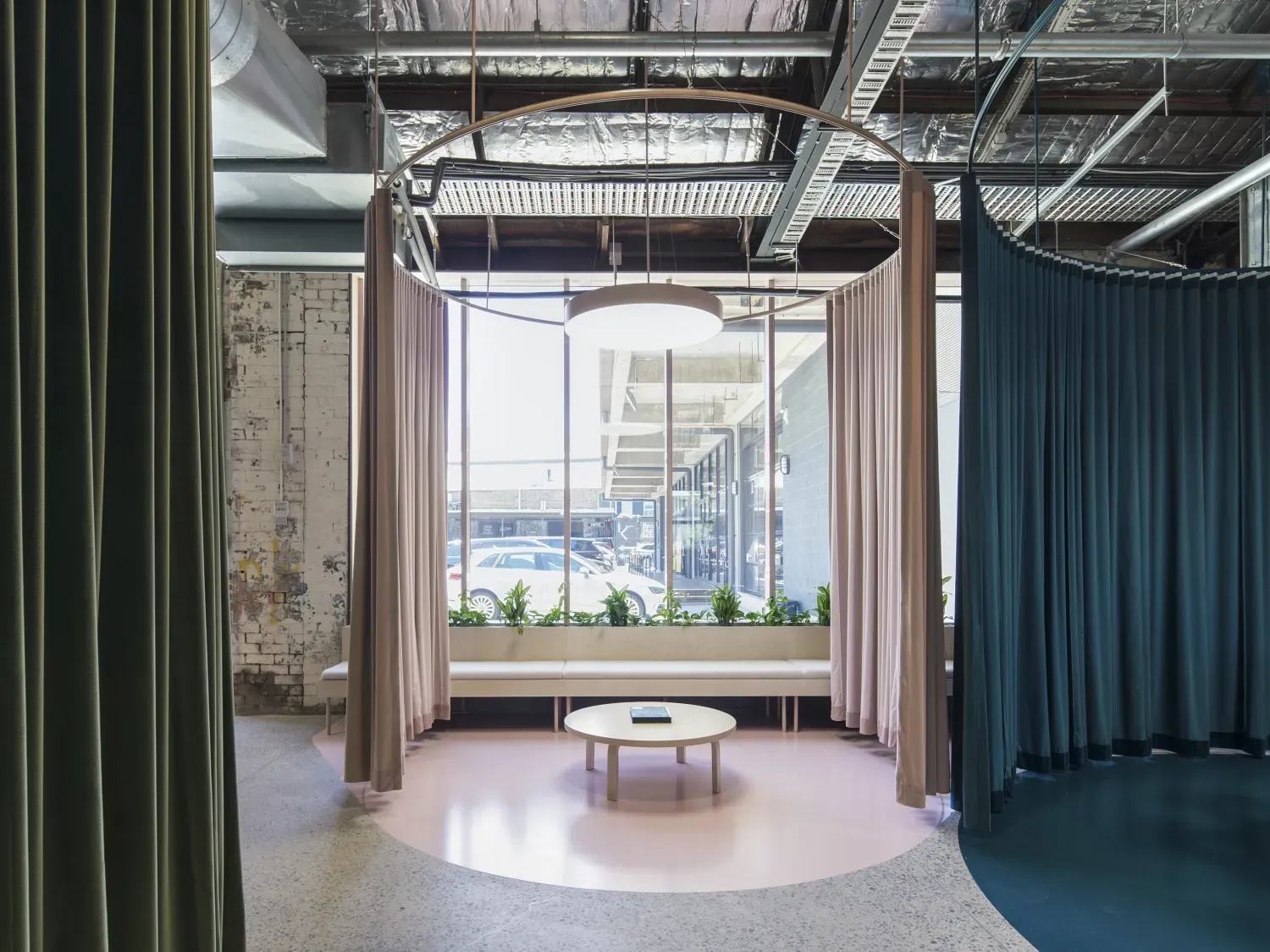 A room with a table and curtains hanging from the ceiling.