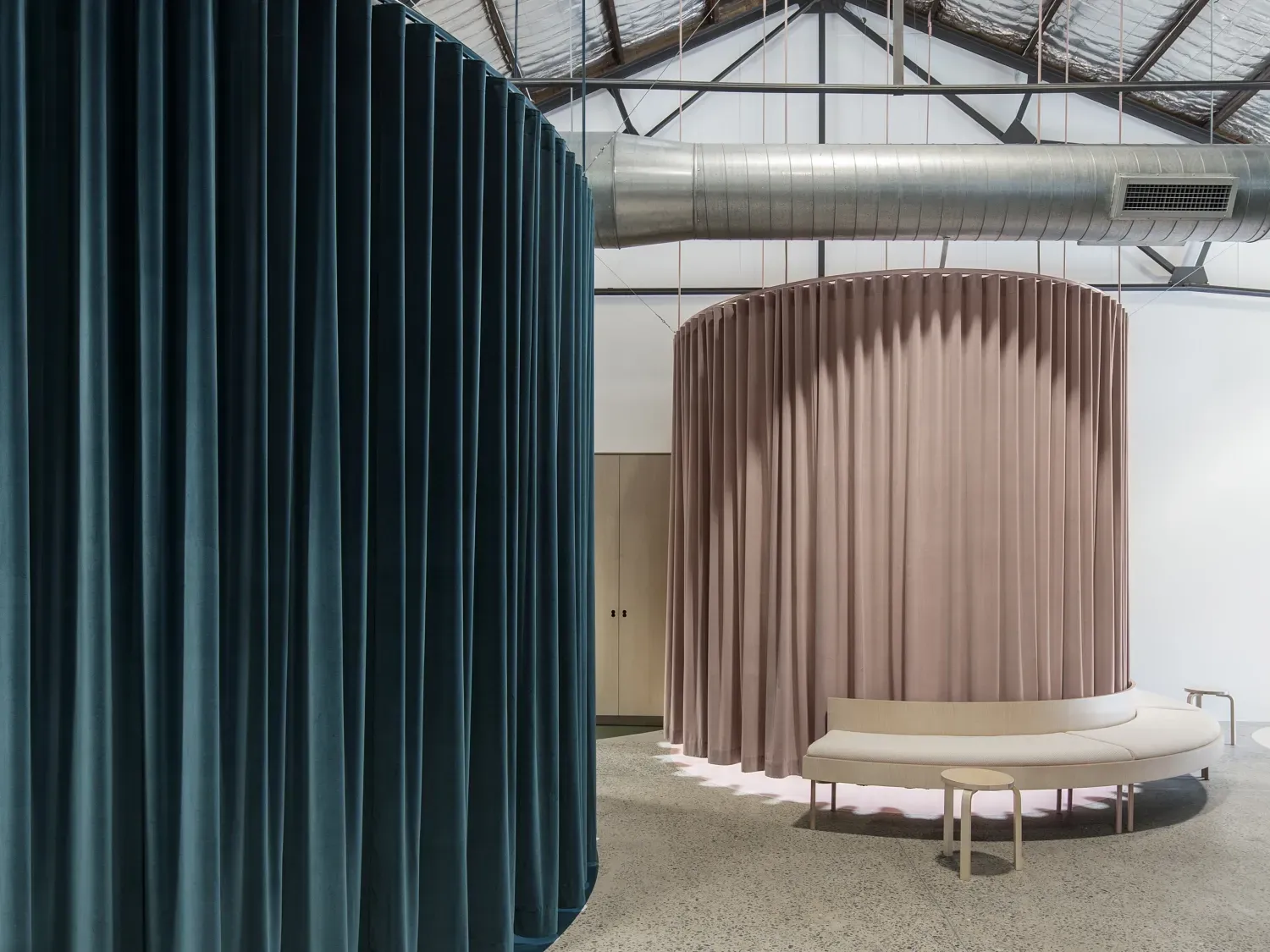 There are two curtains hanging from the ceiling in a room.