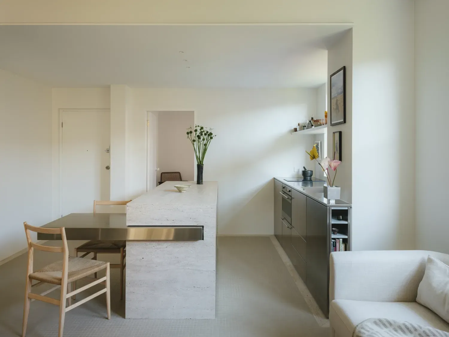 A living room with a table and chairs and a kitchen