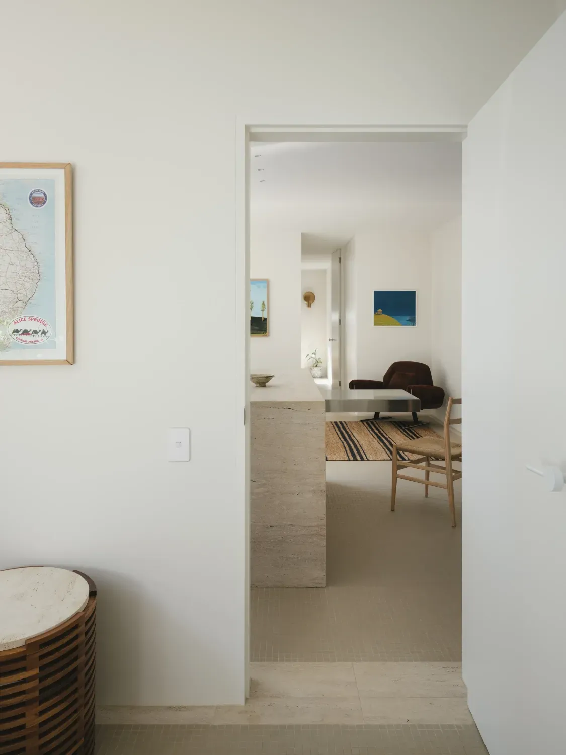 A doorway leading to a living room with a map on the wall