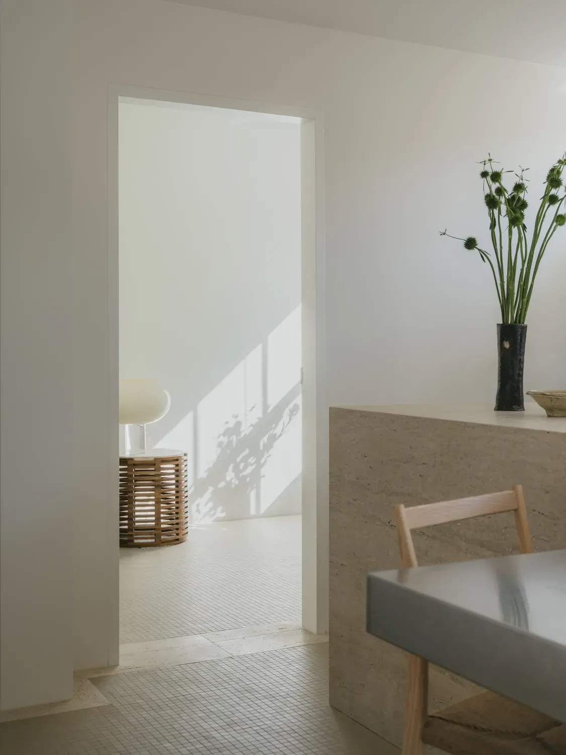 A room with a table and chairs and a vase of flowers