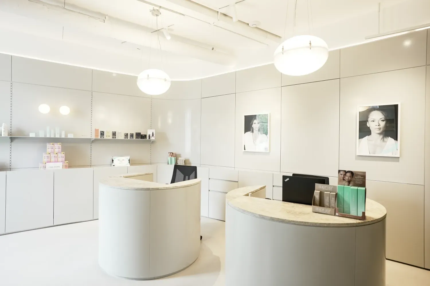 A white room with two round tables and a picture of a woman on the wall.