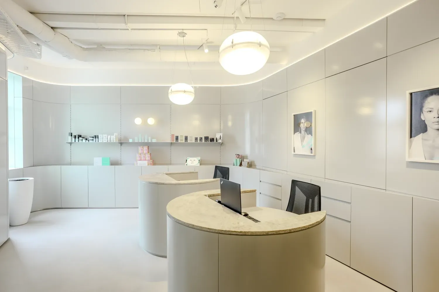 A white room with a round table and a laptop on it.