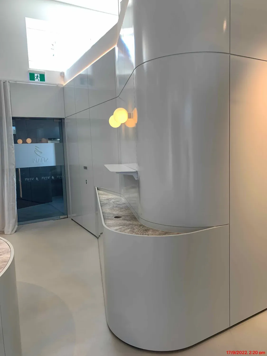 A hallway with a curved wall and a counter in a building.