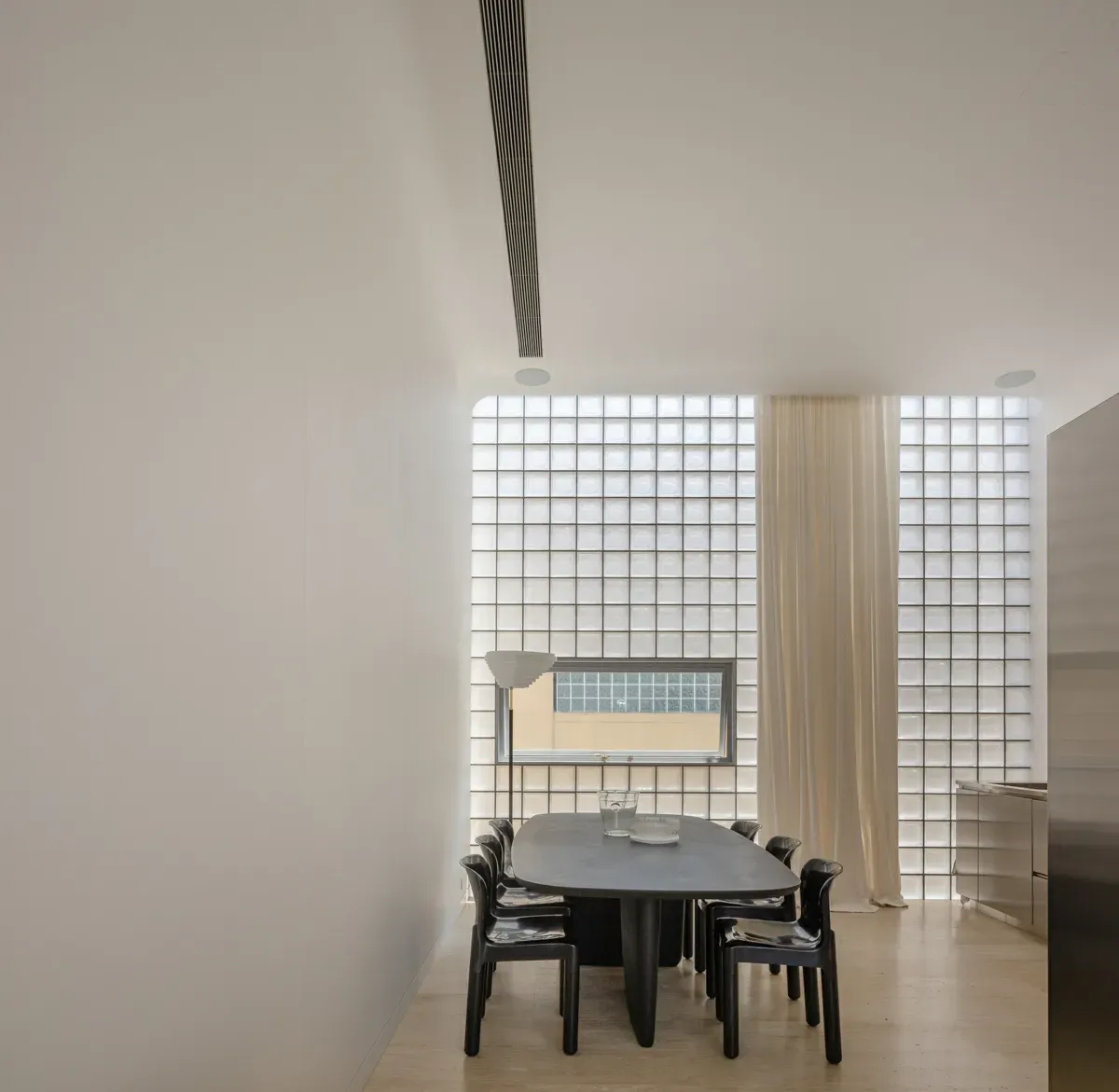 A dining room with a table and chairs in front of a window