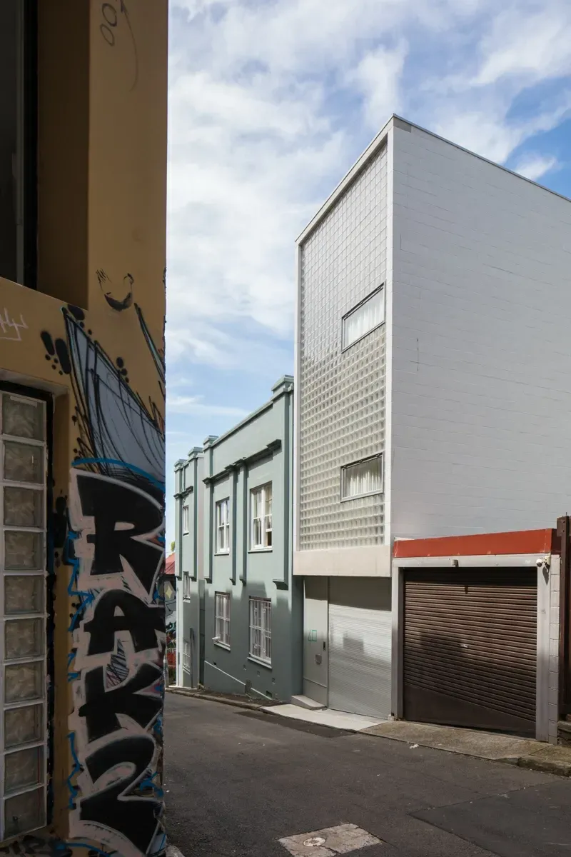 A corner of a street with graffiti on the side of a building