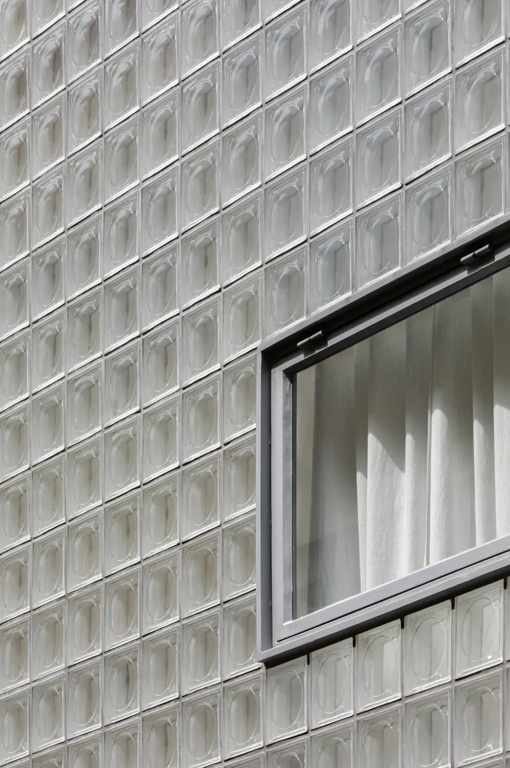 A window on the side of a building made of glass blocks.