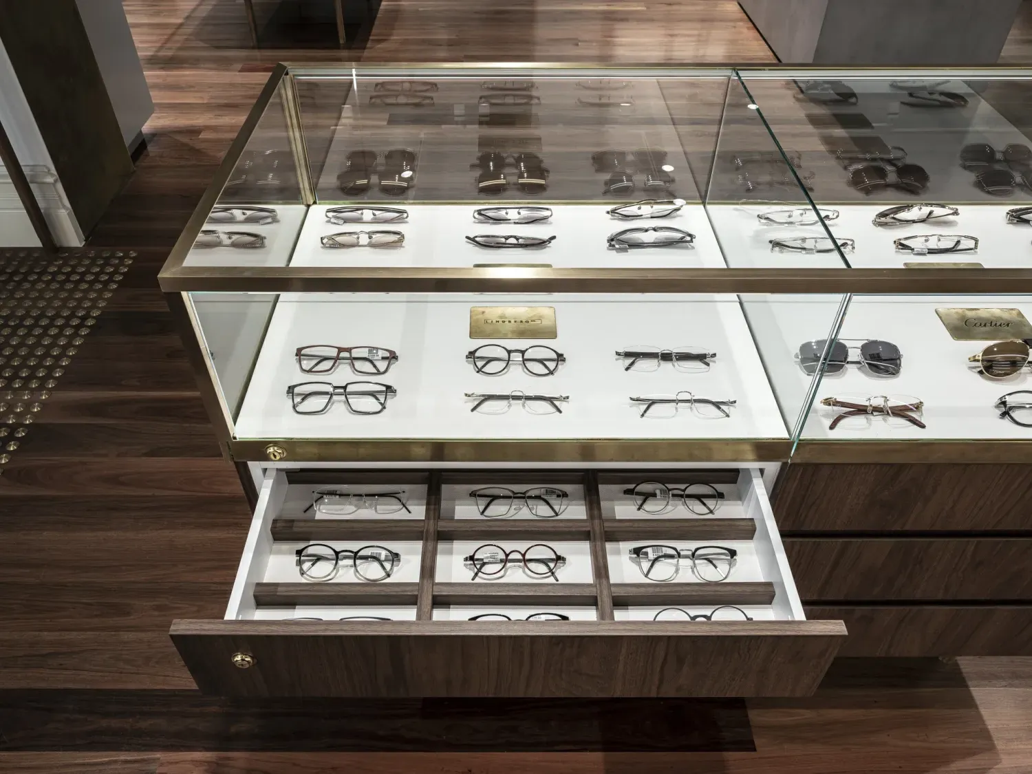 A display case filled with glasses and sunglasses in a store.