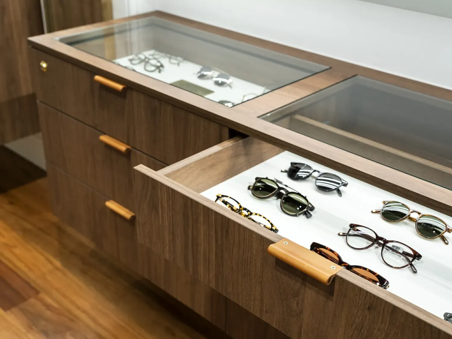 A drawer filled with sunglasses and a glass top