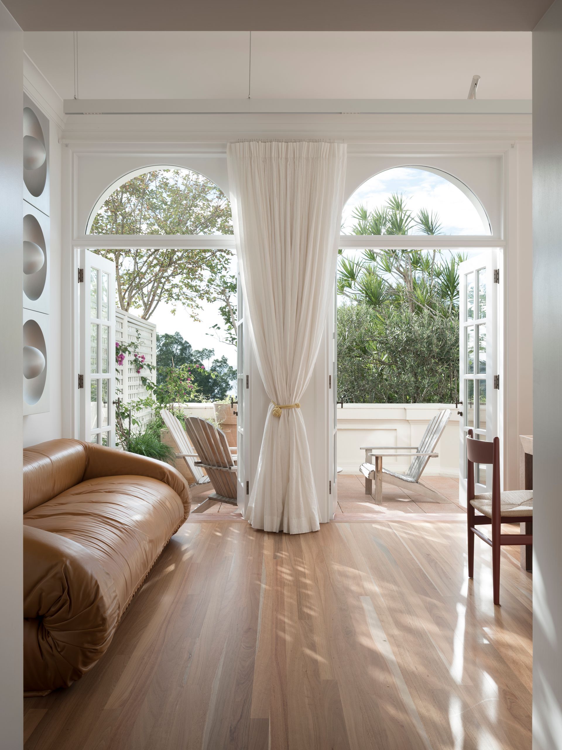A living room with a couch , chairs , and a large window.