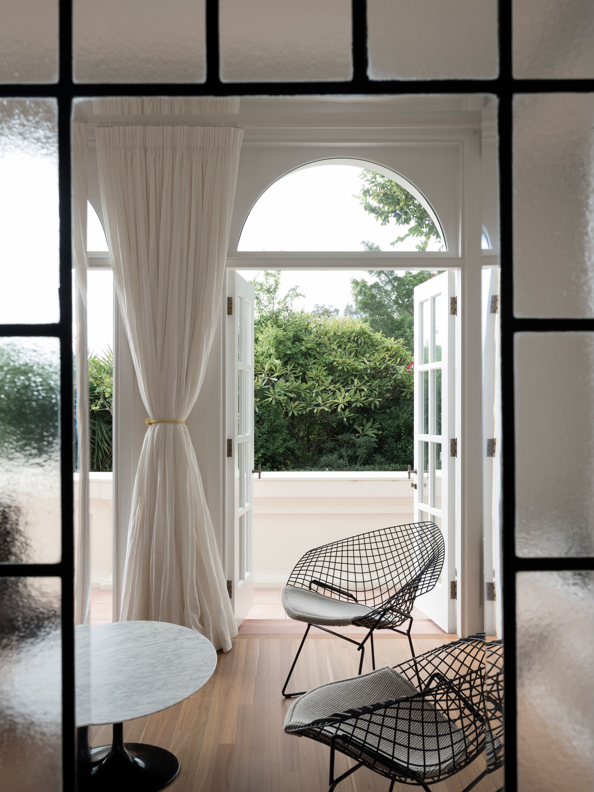 A living room with a table and chairs and a balcony