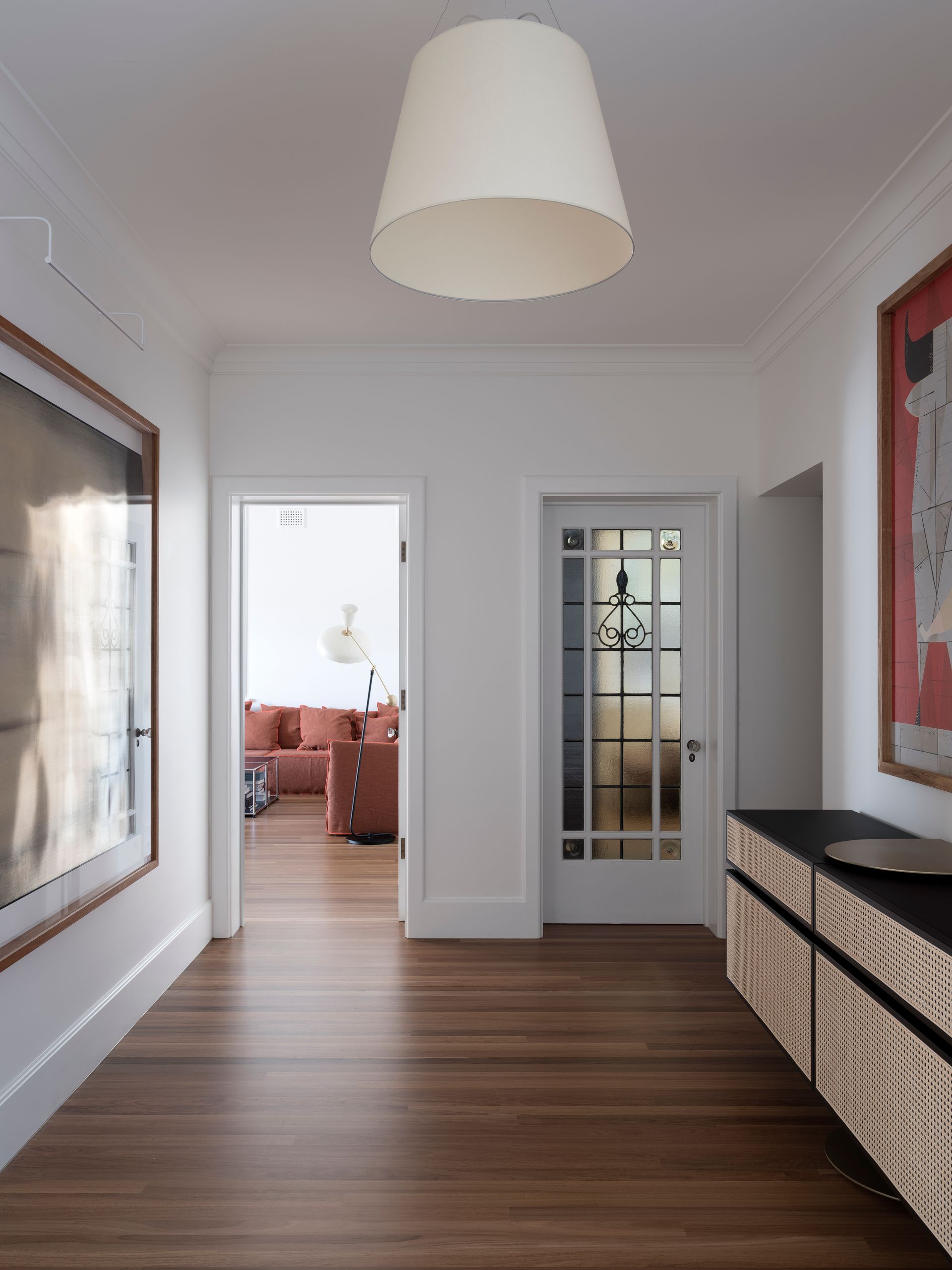A hallway with a lamp hanging from the ceiling
