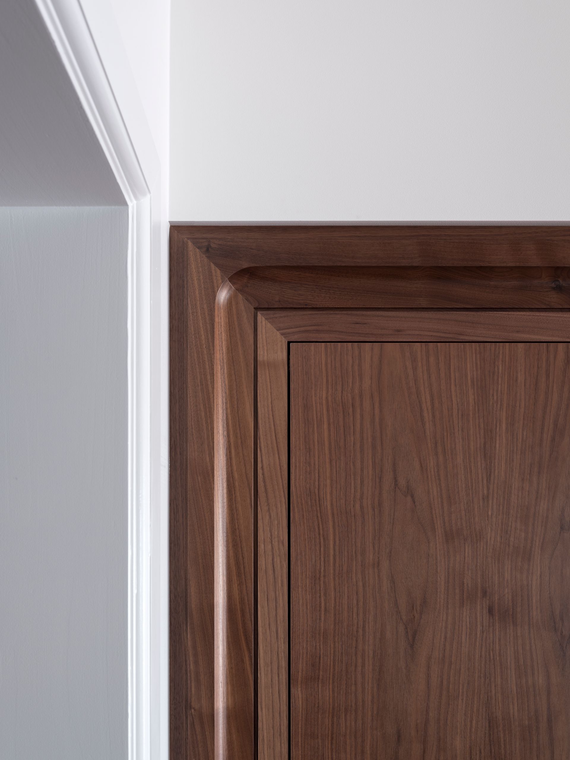 A close up of a wooden door with a white trim.