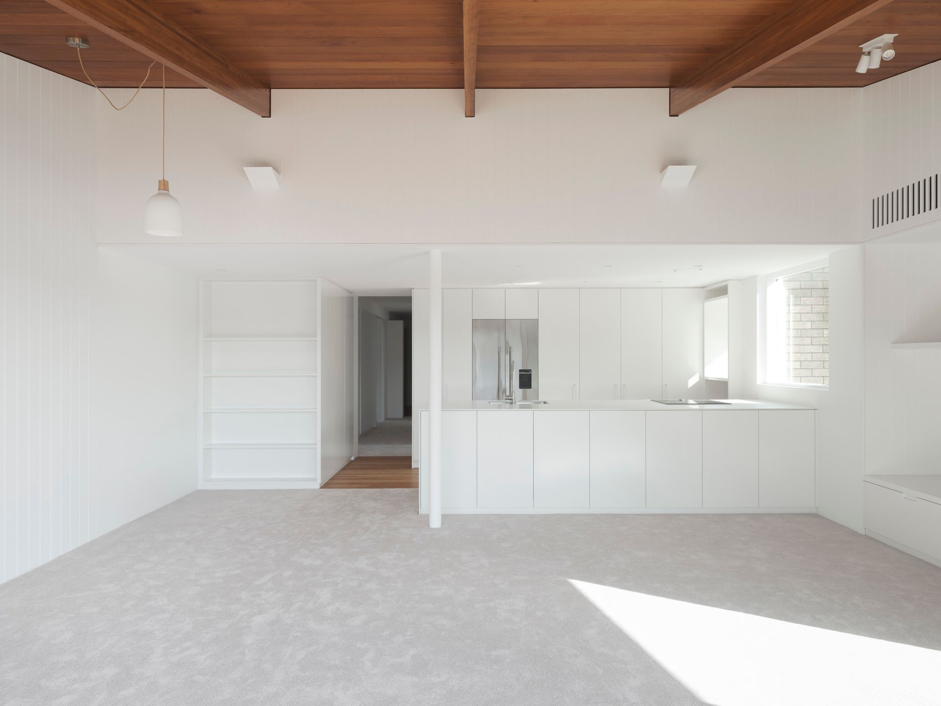 An empty room with white walls and a wooden ceiling