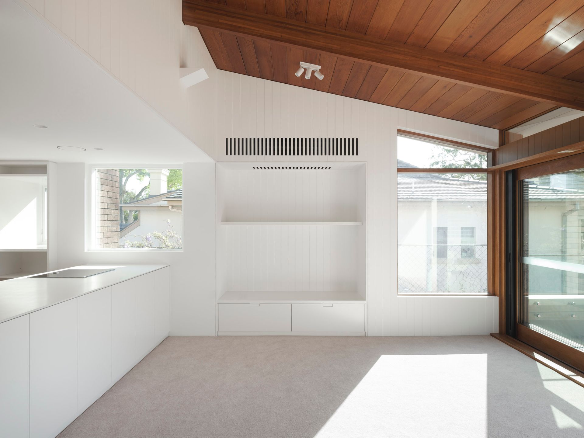 An empty room with a wooden ceiling and white walls