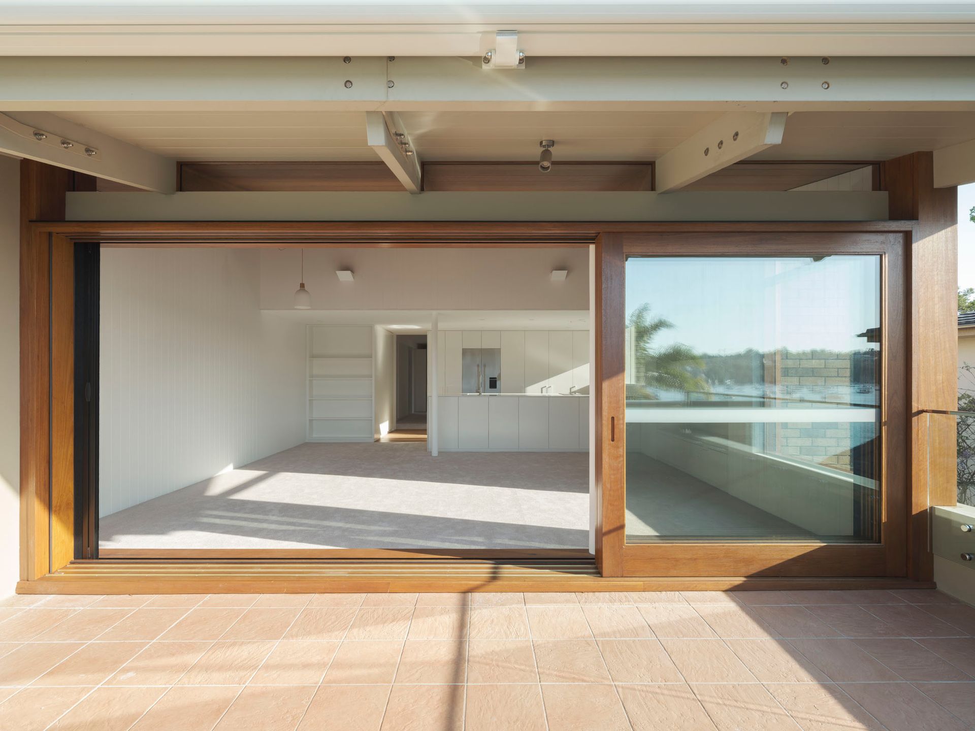 An empty room with a sliding glass door leading to a balcony.