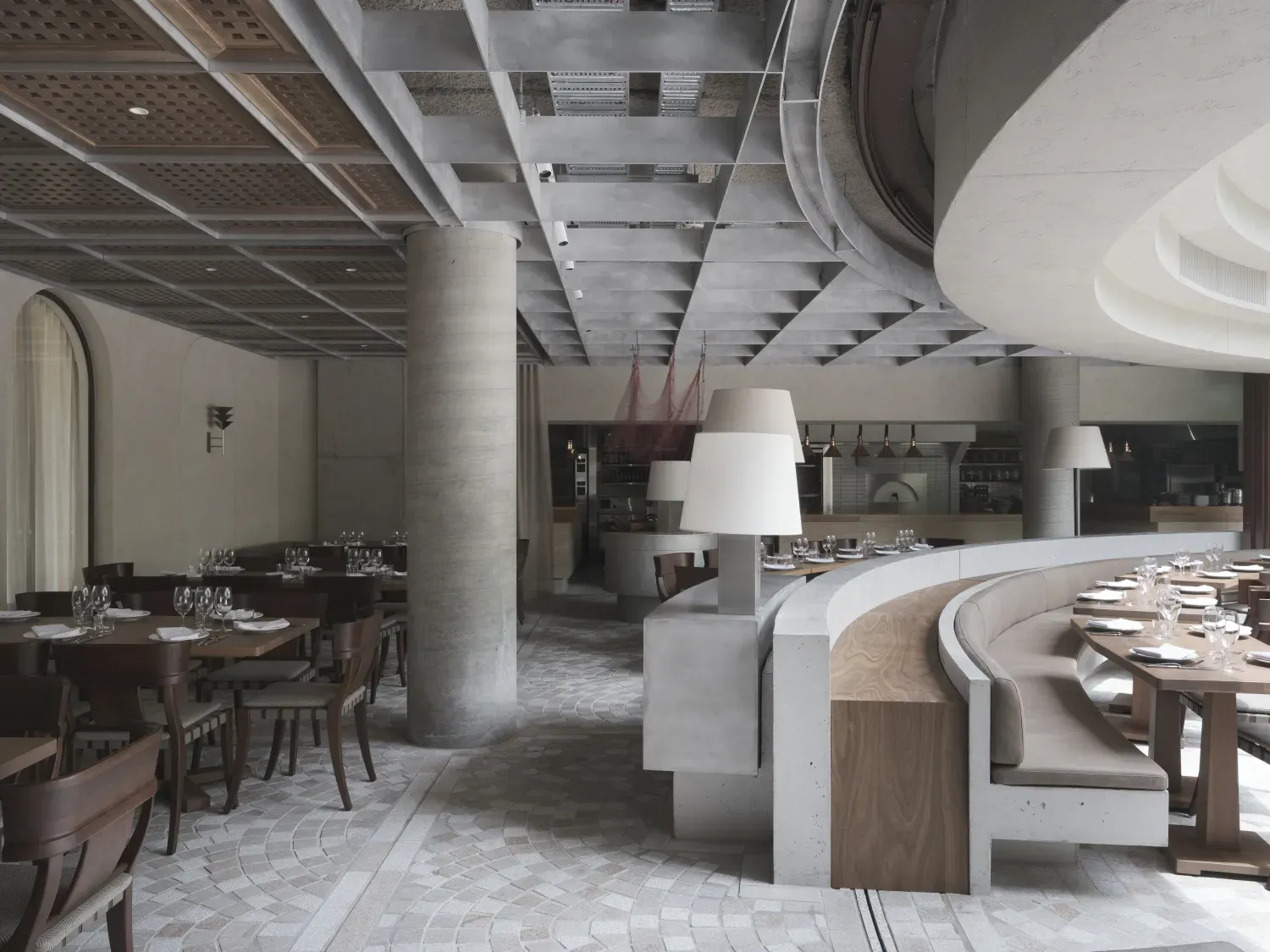 A restaurant with tables and chairs and lamps on the ceiling