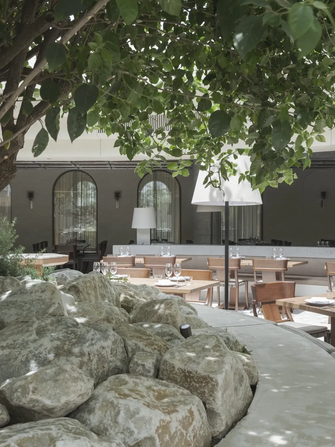 A restaurant with tables and chairs under a tree