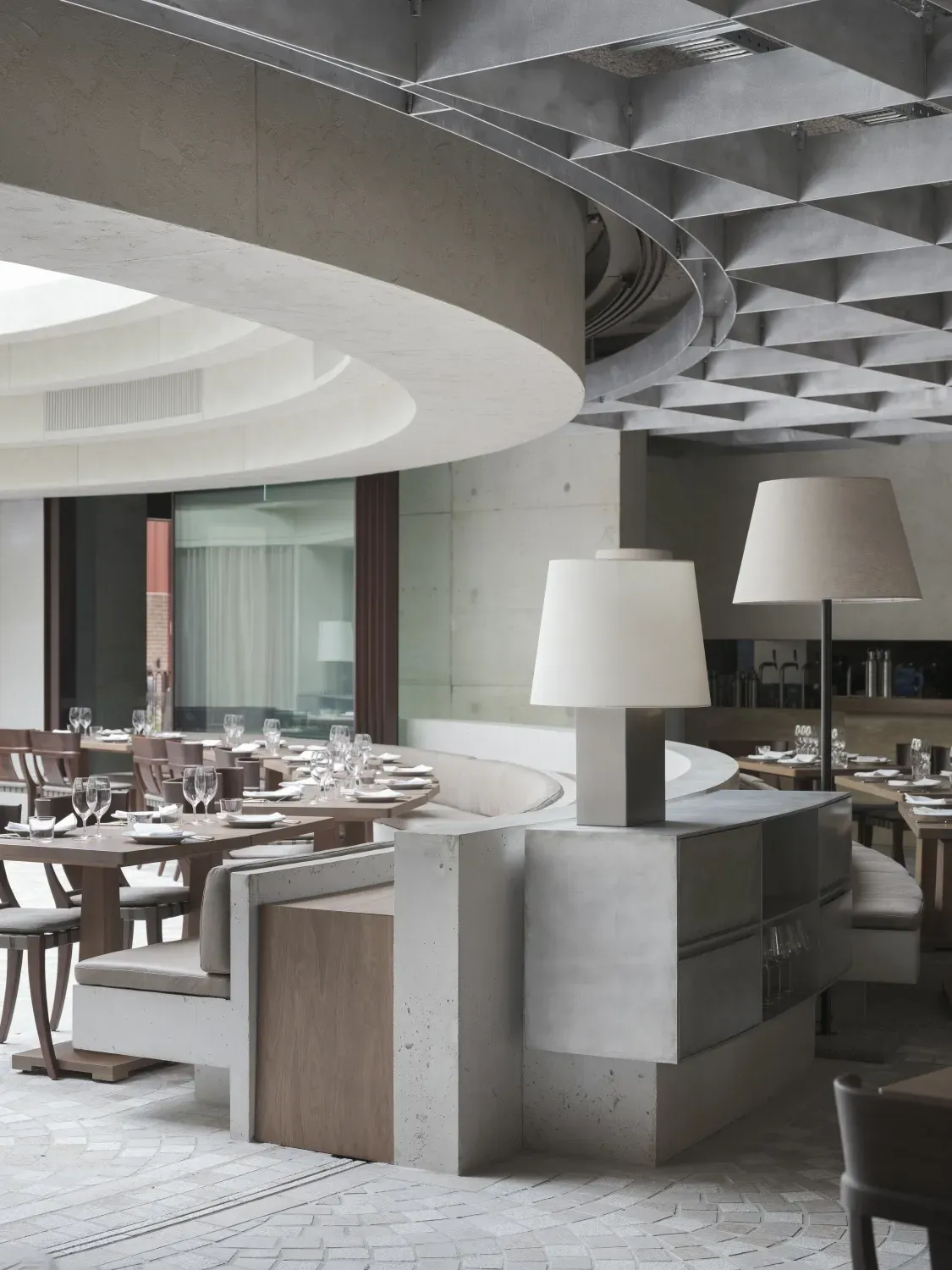 A restaurant with tables and chairs and two lamps