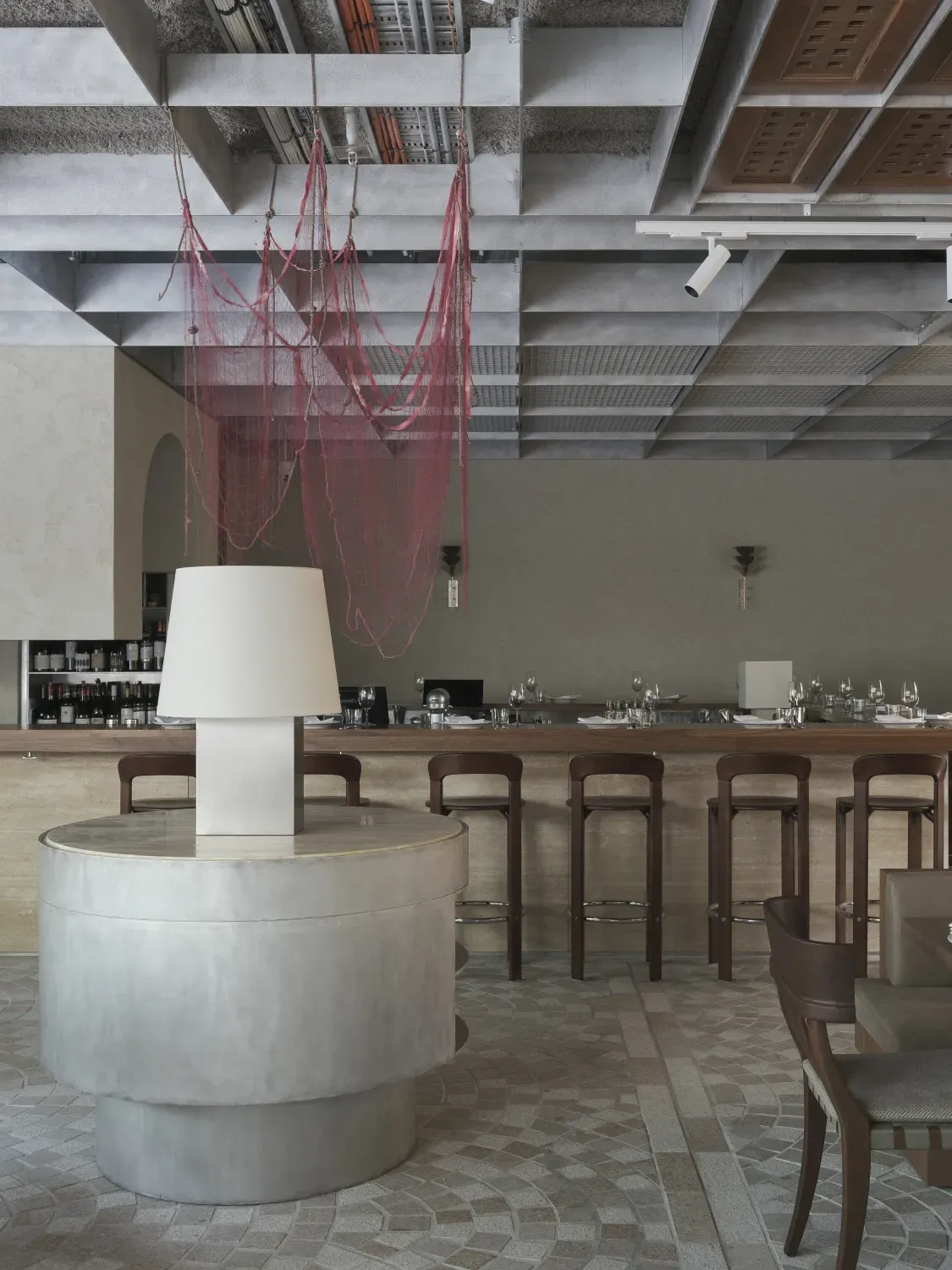 A restaurant with tables and chairs and a lamp on a table