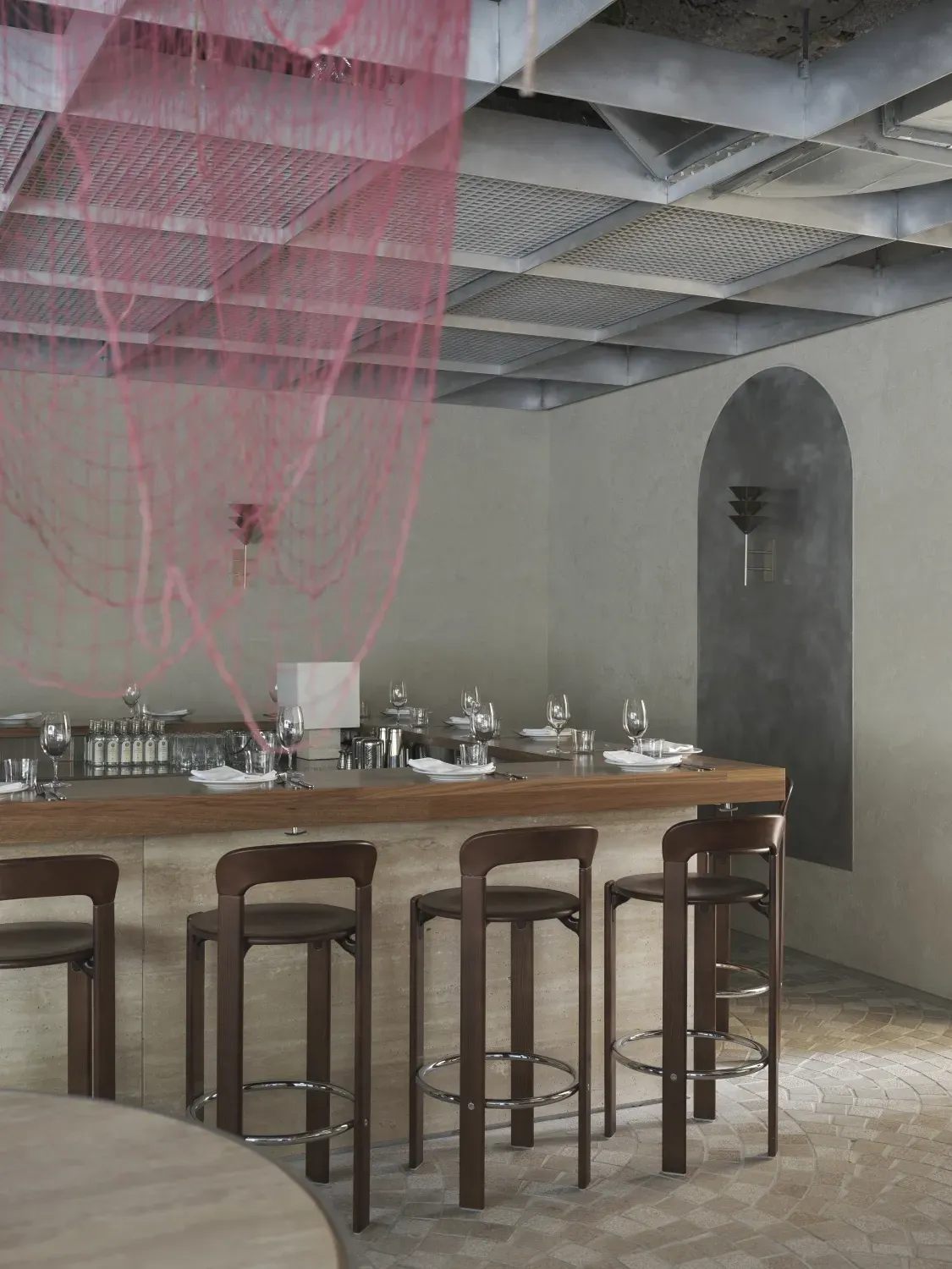 A restaurant with a long wooden bar and stools