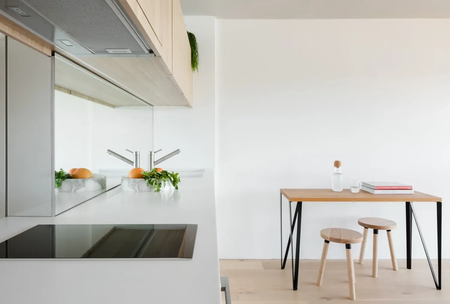 A kitchen with a table and stools and a stove top oven.