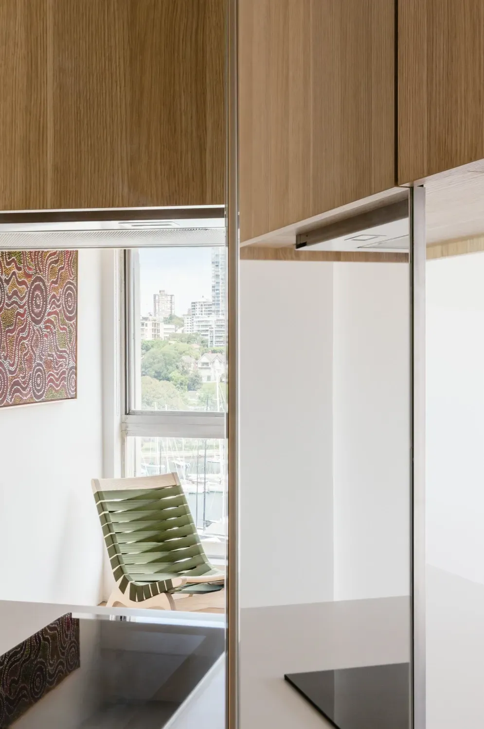 A kitchen with a sink , stove , chair and window.