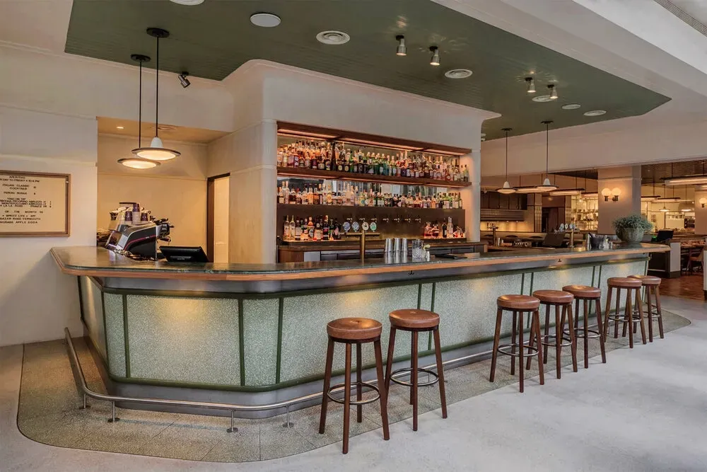 A restaurant with a long bar and stools