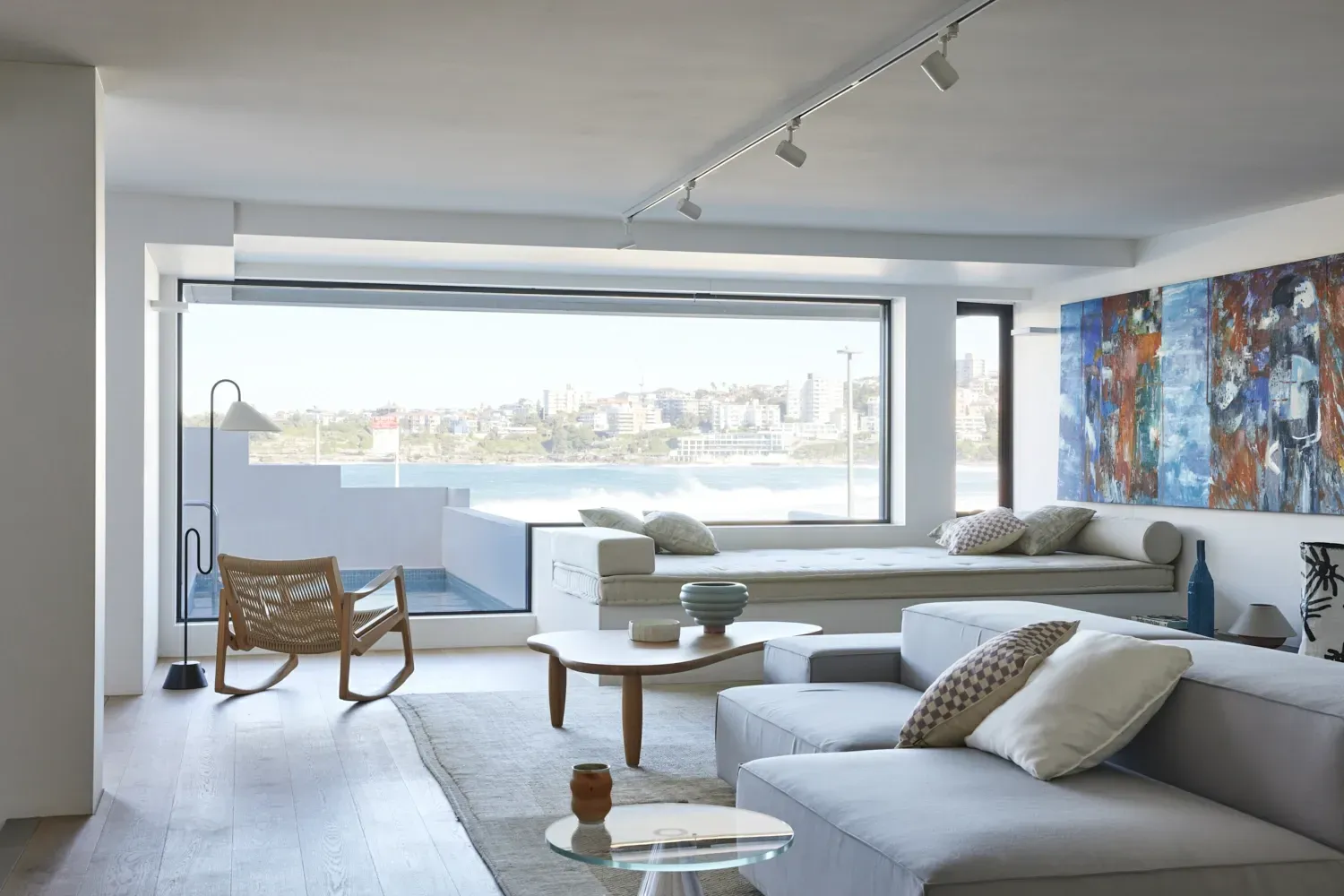 A living room with a couch , table , chair and large window.