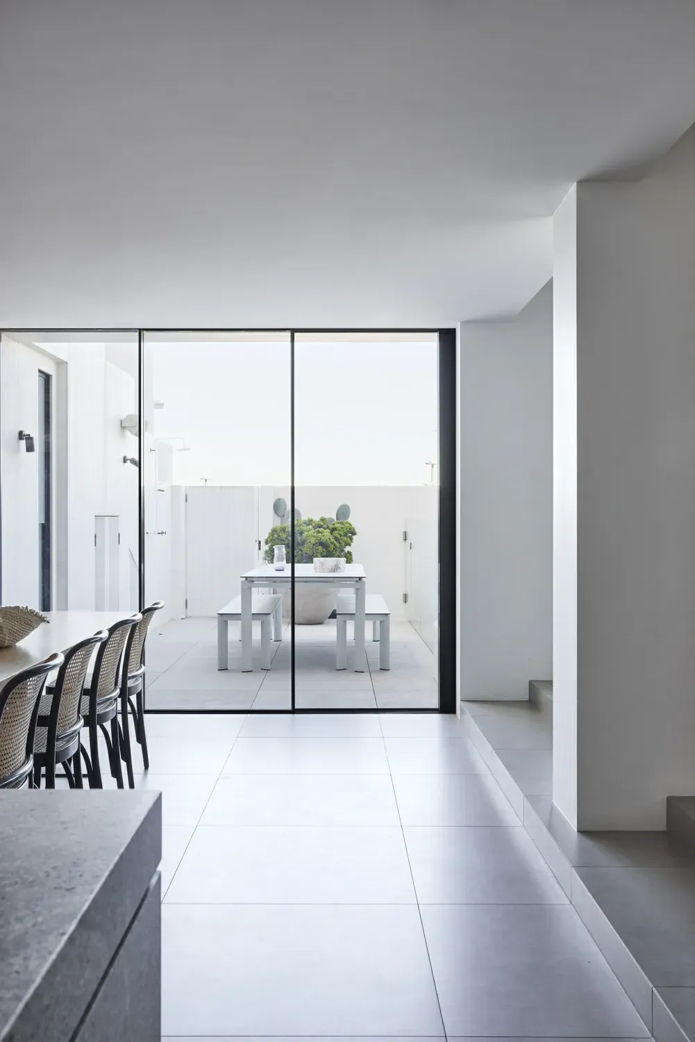 A dining room with a table and chairs and a sliding glass door leading to a patio.