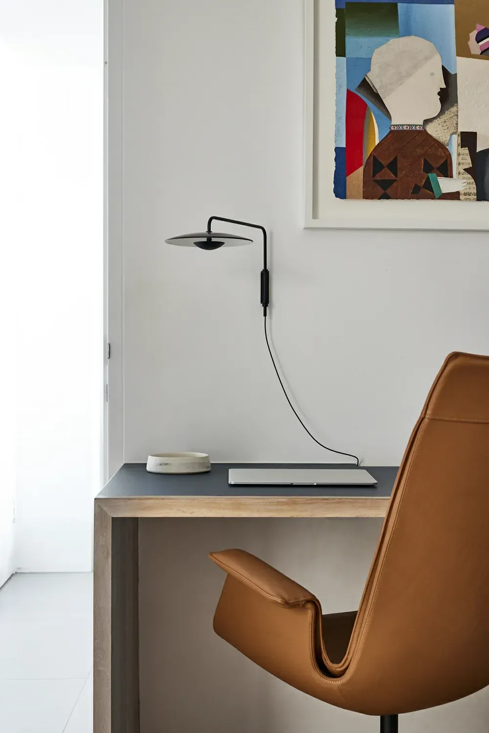 A desk with a chair and a lamp on it