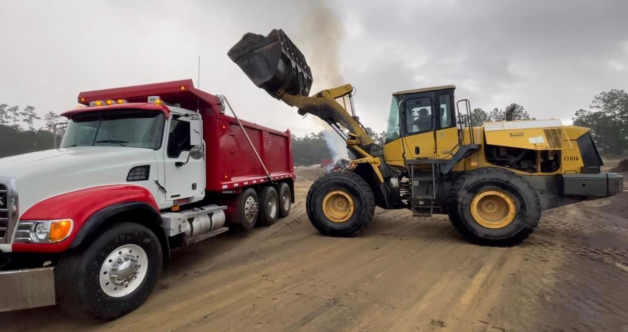 Excavator pouring soil on a truck